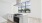 a kitchen with white cabinets and a large windo