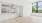 a room with white walls and a wood floor with a window