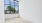 a room with a wood floor and a window with a view of trees